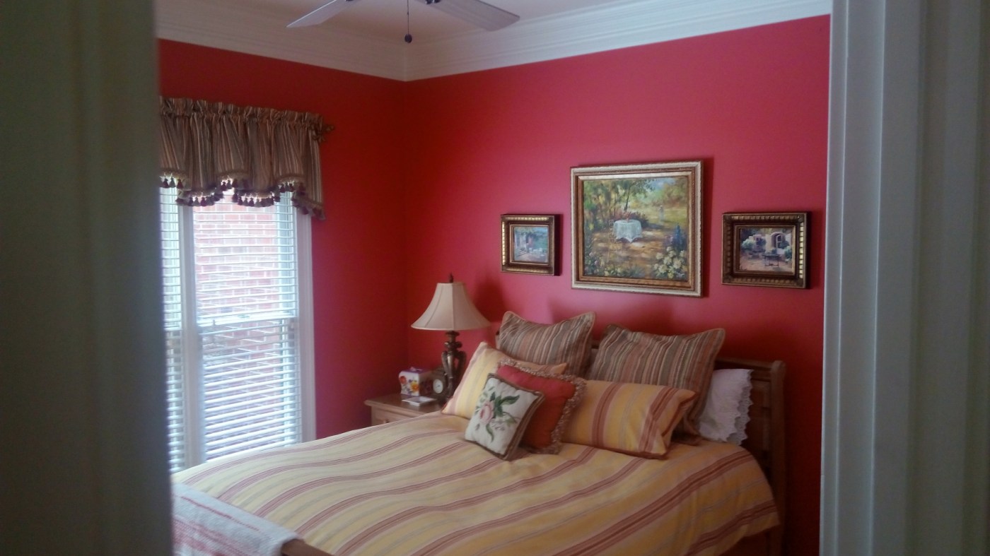 Guest bedroom painted a bold raspberry red with white crown molding