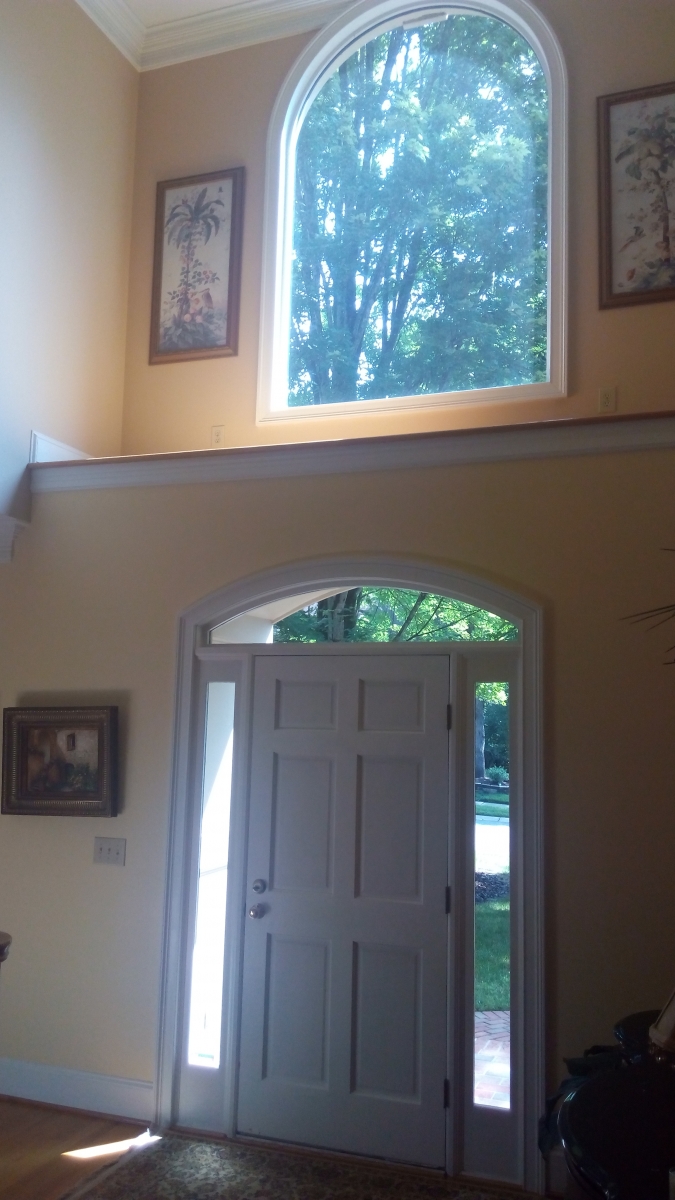 Two-story entry foyer with painted walls, trim and arched window casing