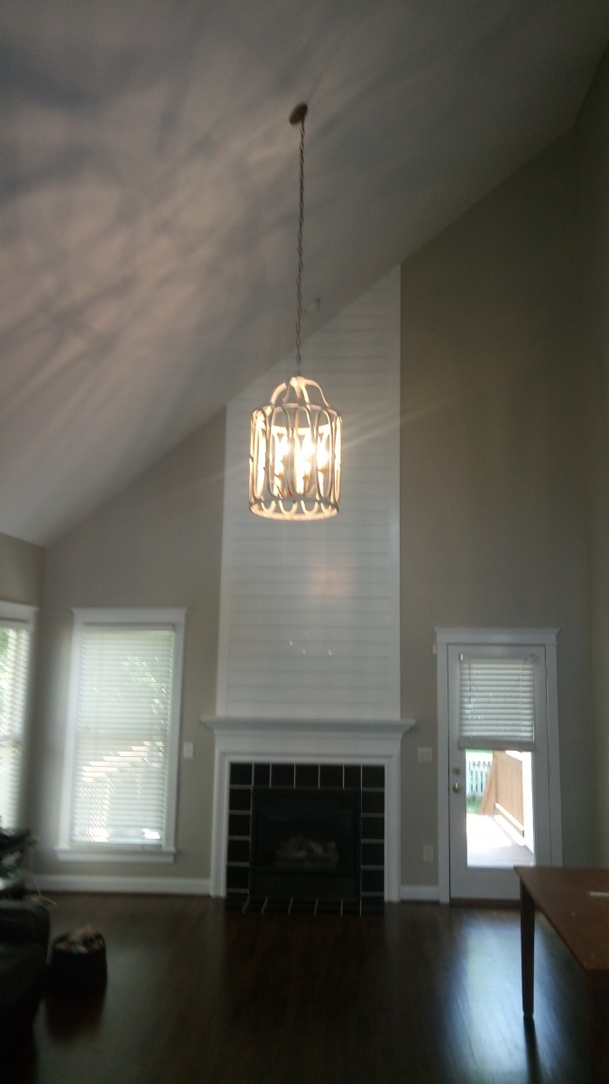Two-story great room with a painted shiplap fireplace surround