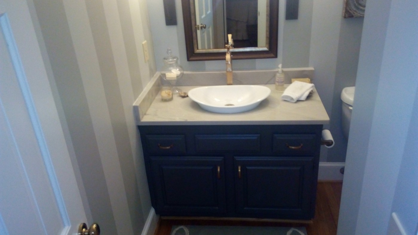Powder room after: striped walls and a navy refinished vanity