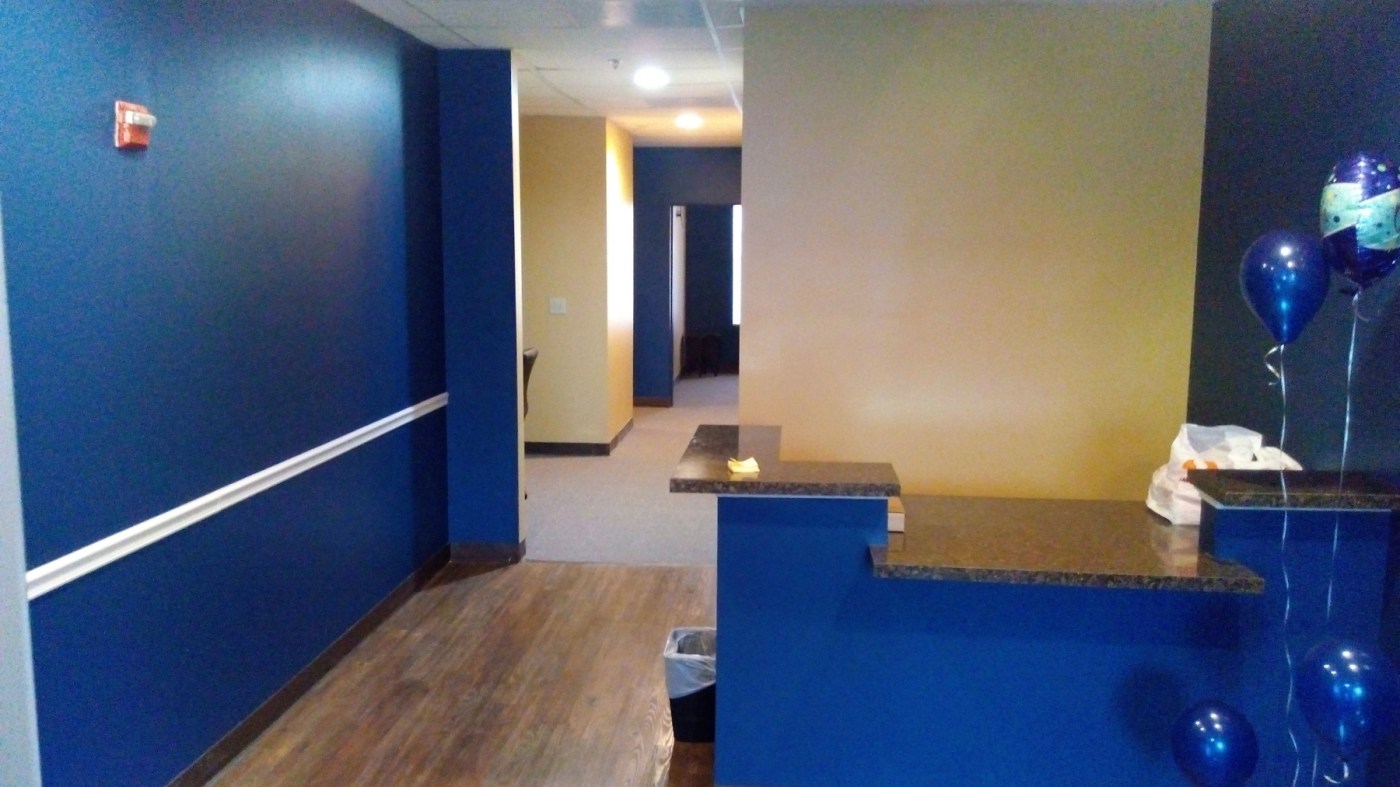 Commercial office painted in blue and gold with a white chair rail