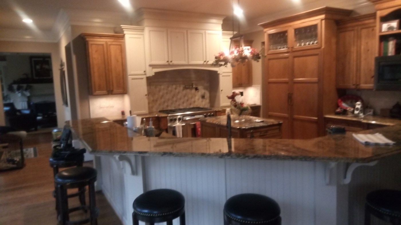 Two-tone kitchen: upper cabinets and hood painted white, island left natural