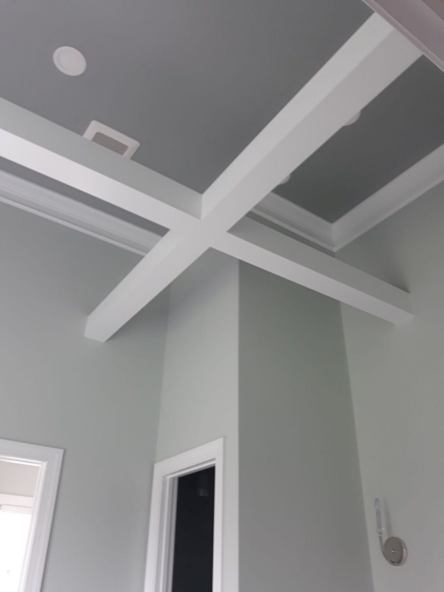 Coffered ceiling with crisp white beams over soft gray walls