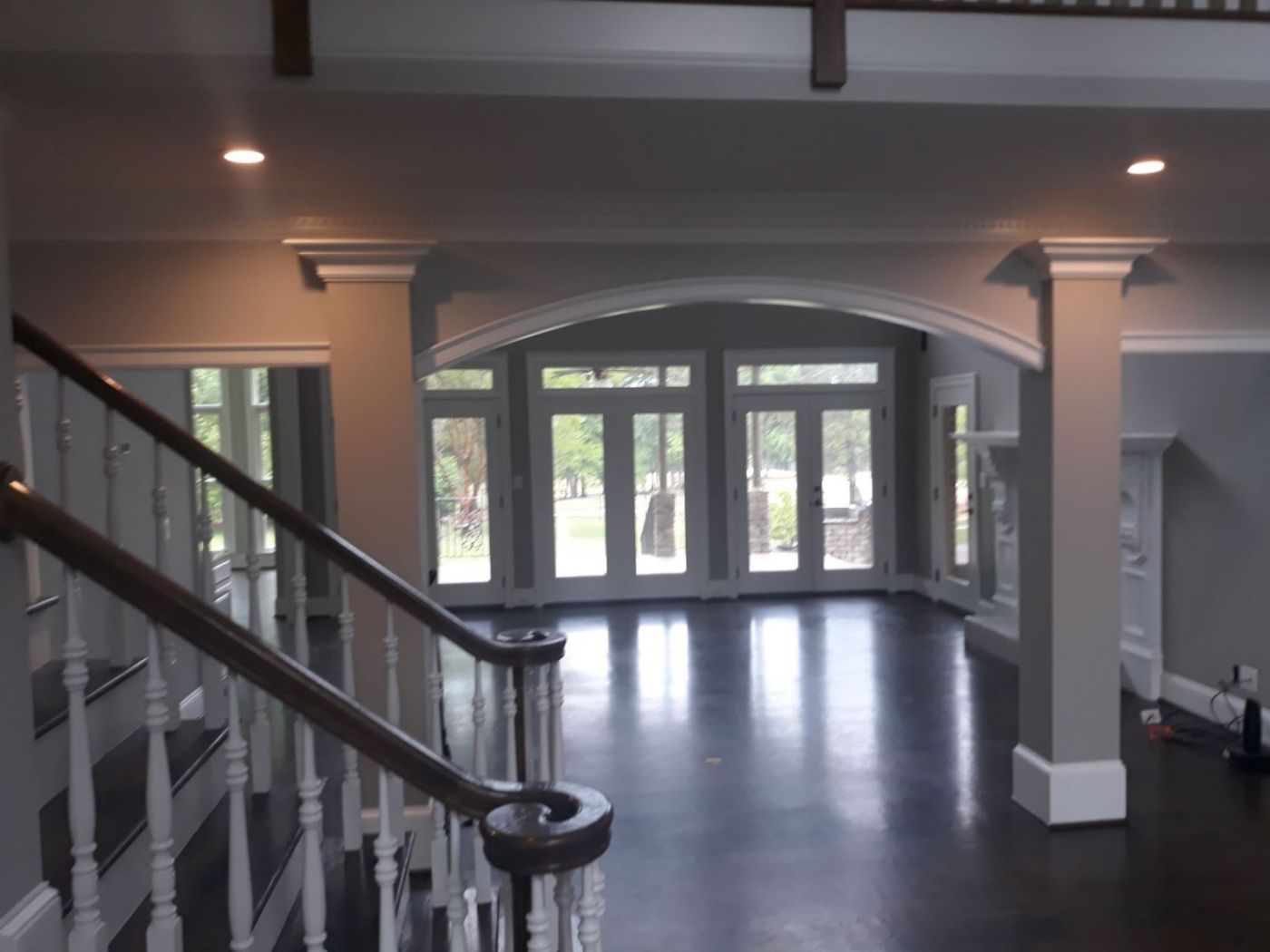 Open foyer and stair hall painted a warm gray with white columns