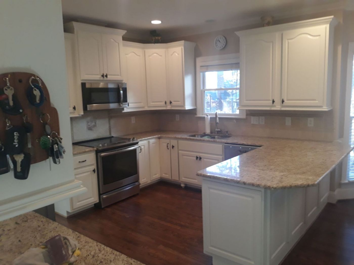Cathedral-door kitchen cabinets refinished in a warm white