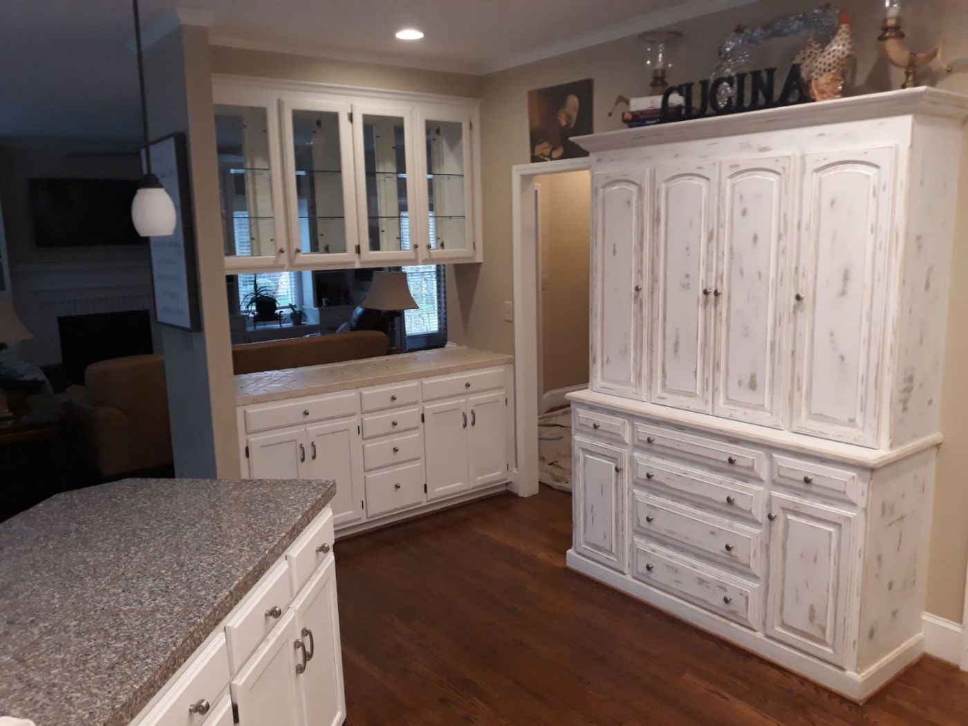 Kitchen cabinetry given a hand-distressed antique white finish