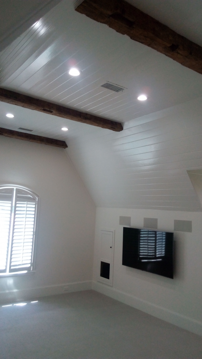 Bonus room with a white shiplap vaulted ceiling and rustic beams