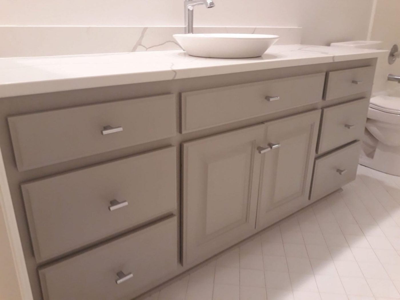 Bathroom vanity refinished in greige under a quartz countertop